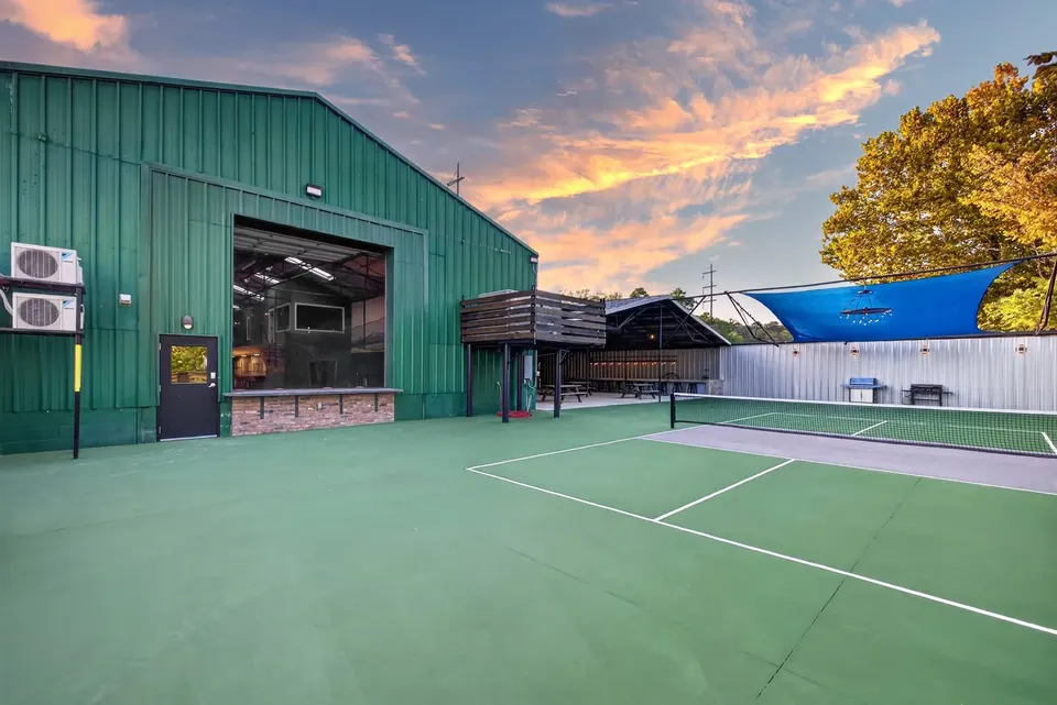 The court beside the green clubhouse building